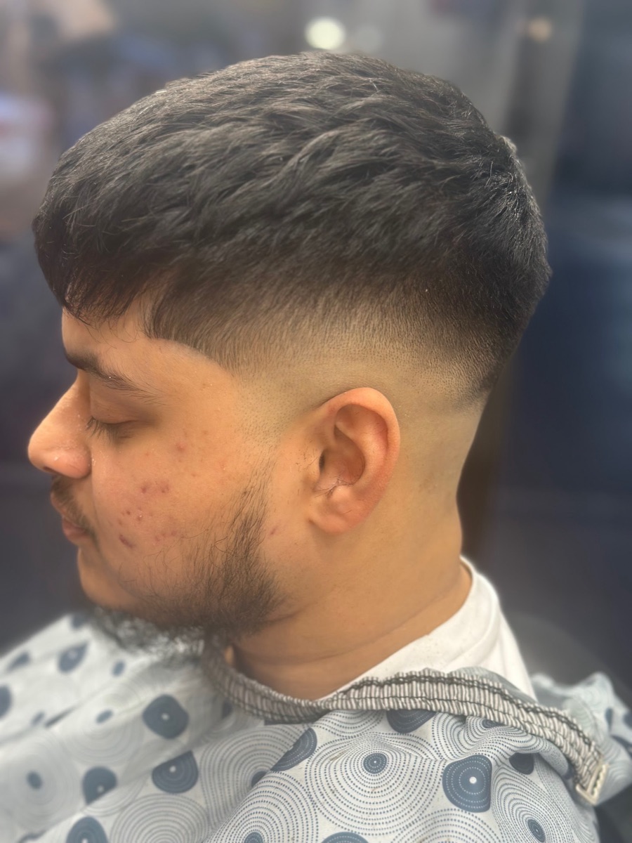 A sharp taper skin fade with textured top and neat beard blend, cut at The Clip Joint Hackney